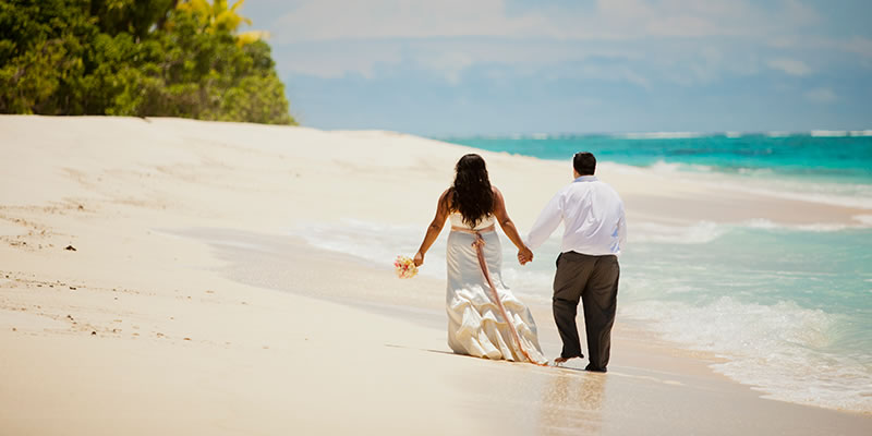 Bride and groom walking along a beach