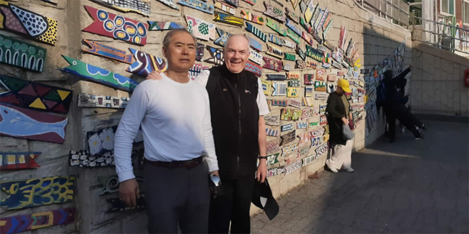 Fr. John Boles and Pelagio in front of one of Gamcheon's murals.