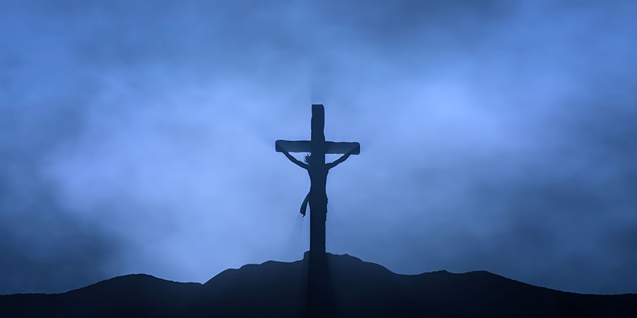 Christ on the cross with a dark blue sky background