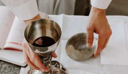Priest holding the body and blood of Christ during Mass
