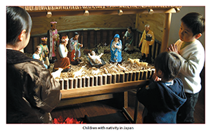 Children standing in front of a nativity scene in Japan