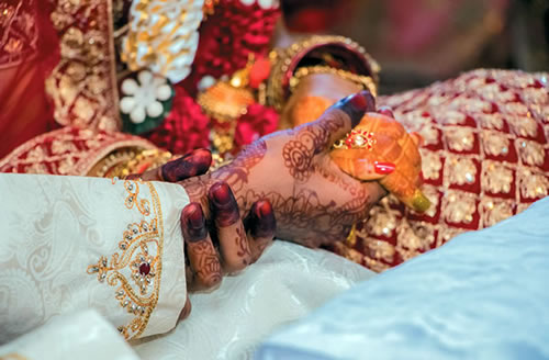 Decorated hands of the wedding couple Aidan and Praveena