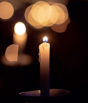 A lit candle in a dark room