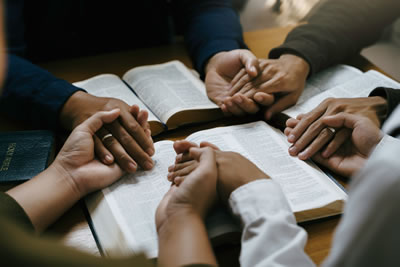 Hands clasped around a table