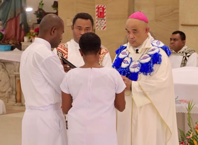 Archbishop Peter Loy blesses Aloisio Tamatawale and his wife