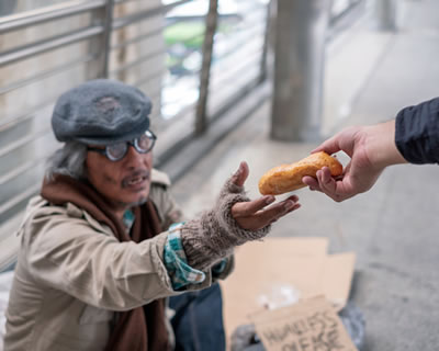 Good Samaritan giving food to a homeless person