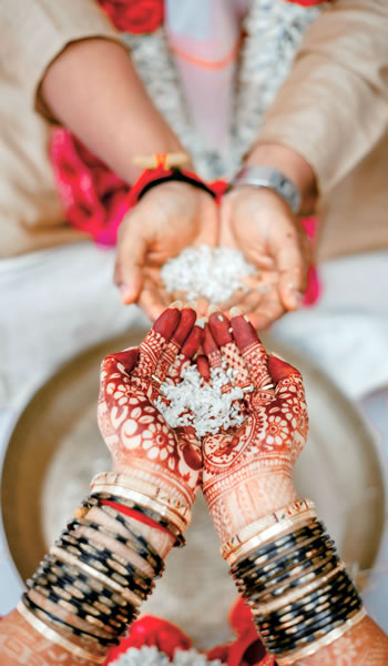 The hands of two people holding rice.