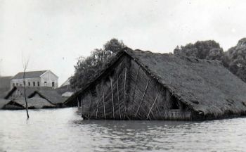 Flooding covers all but the roof of a mat house