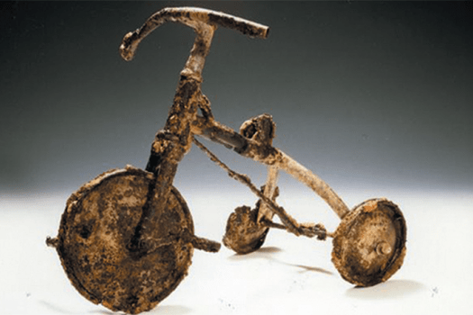 A child's tricycle, burnt and twisted, at the Atomic Bomb Memorial Museum