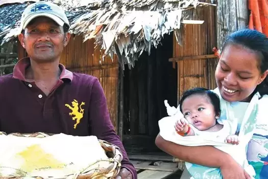 A Subanen crafter carries her baby in a sling.