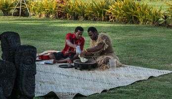 Two people perform the Sevusevu (kava making) ceremony