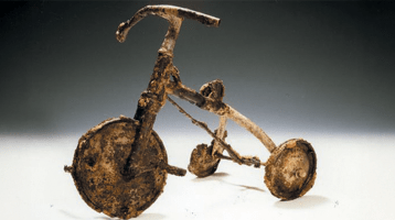 A child's tricycle, burnt and twisted, at the Atomic Bomb Memorial Museum