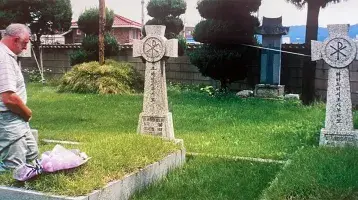 Fr. Ray Collier at his uncle Tony's grave outside Chuncheon Cathedral in Korea during a visit in 2000.