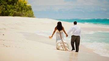 Bride and groom walking along a beach