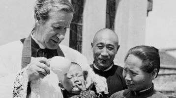 Bishop Edward Galvin baptizing a baby