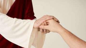 Jesus clasping the hand of a person.