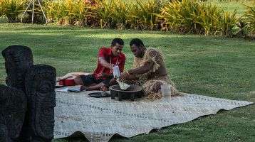 Two people perform the Sevusevu (kava making) ceremony
