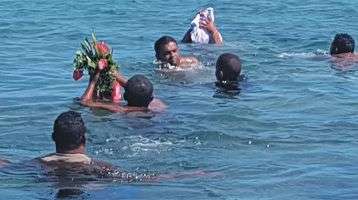 People in the water return person's ashes to the sea.