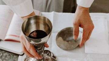 Priest holding the body and blood of Christ during Mass