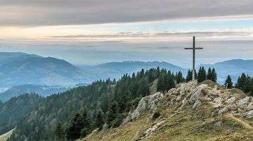 A cross on top of a rocky mountain