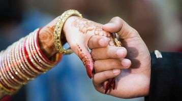 Bride and groom hold hands during Pakistani wedding