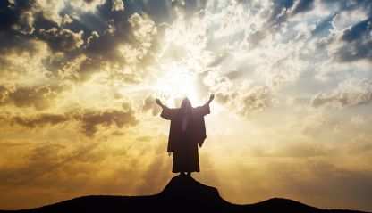 Jesus on a mountaintop with hands raised looking over the world