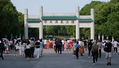 Facade of Wuhan University campus gate. With students and tourists.