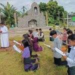 Students kneeling at the stations, reading a reflection