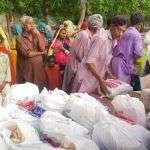 People in line to get food and mosquito nets in Issu Nagar, Mirwa