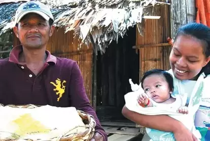 A Subanen crafter carries her baby in a sling.