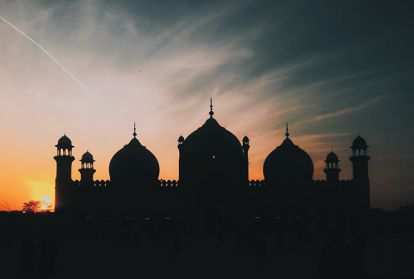 A mosque silhouetted against a setting sun