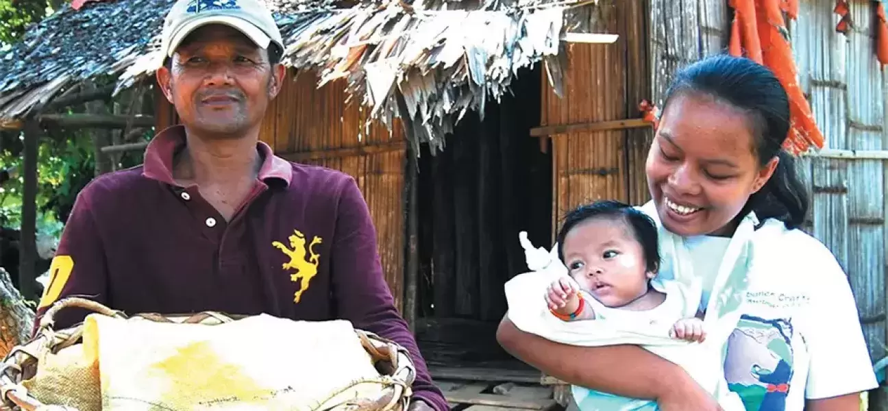 A Subanen crafter carries her baby in a sling.