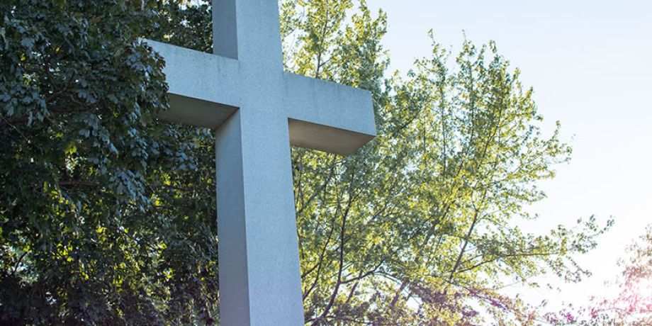 Cross with a tree-lined background
