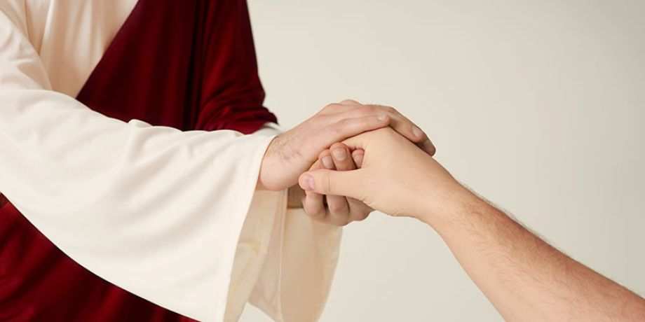 Jesus clasping the hand of a person.