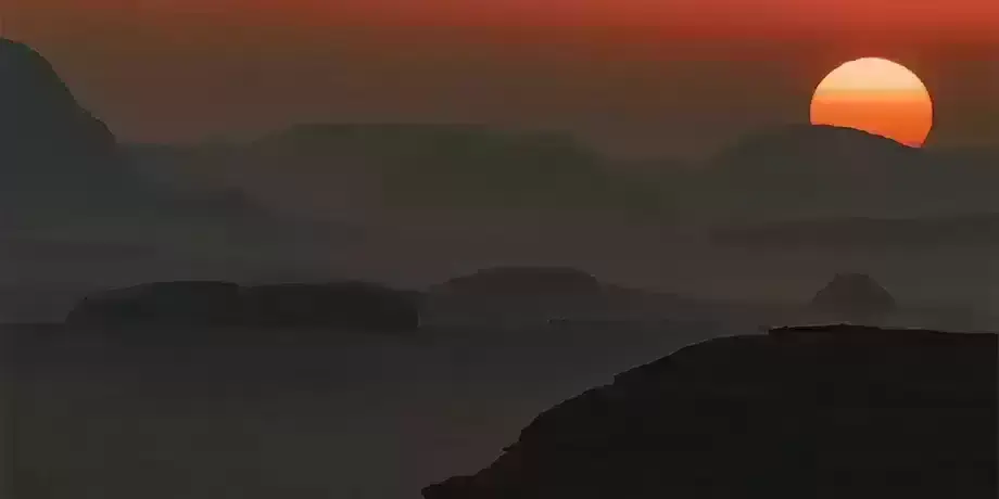 Setting sun over mountainous terrain