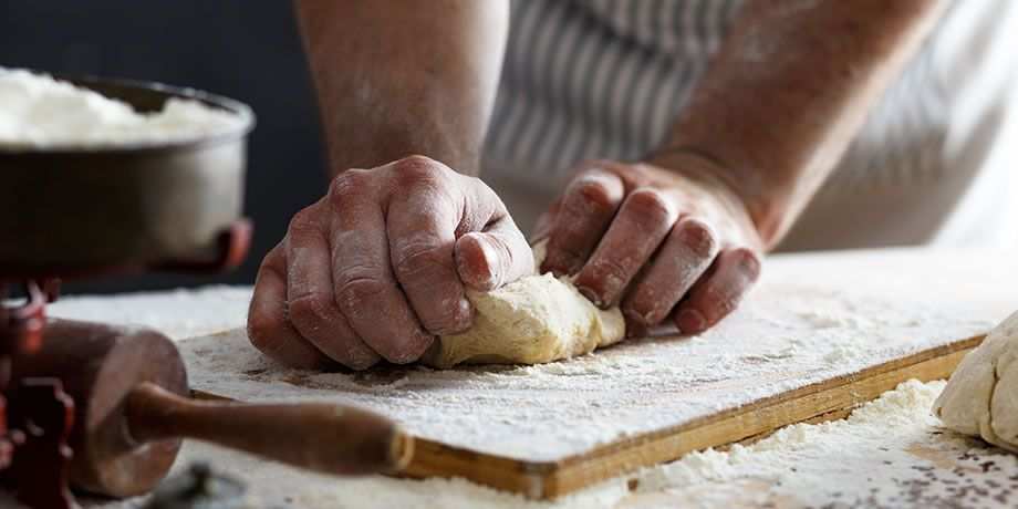 A baker's hands kneading dough.