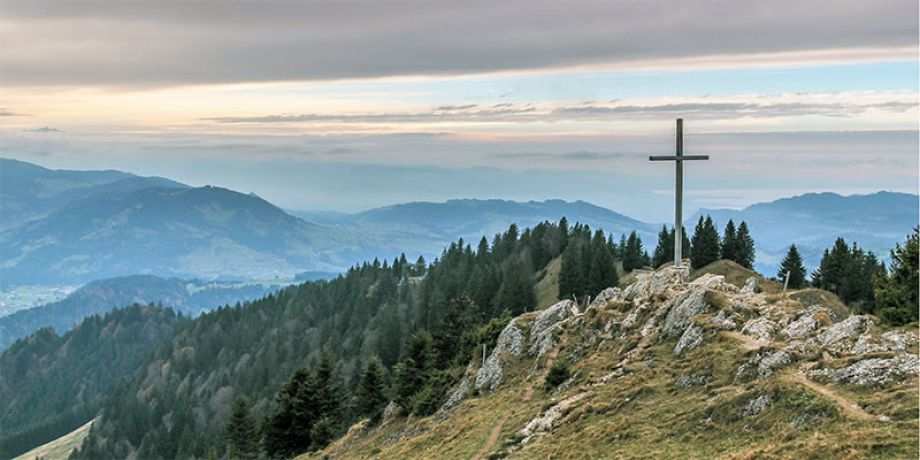 A cross on top of a rocky mountain
