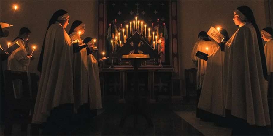 Nuns praying by candlelight in church