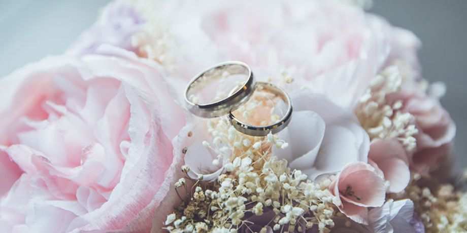 Wedding rings atop a bridal bouquet