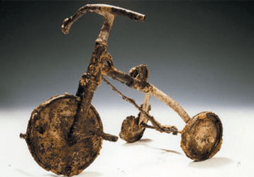 A child's tricycle, burnt and twisted, at the Atomic Bomb Memorial Museum