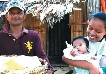 A Subanen crafter carries her baby in a sling.