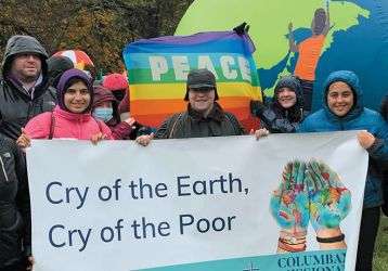 People holding a banner "Cry of the Earth, Cry of the Poor" on Away Day 2024