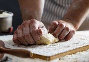 A baker's hands kneading dough.