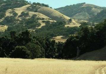 A farm field surrounded by mountains