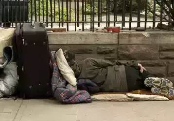 Homeless person sleeping on park bench