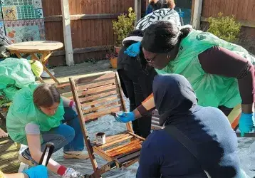Abi (left, bending) painting garden furniture