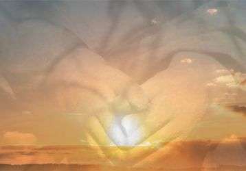 hands superimposed over a sunrise