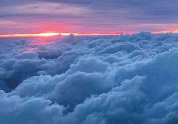 The sun rising above the clouds